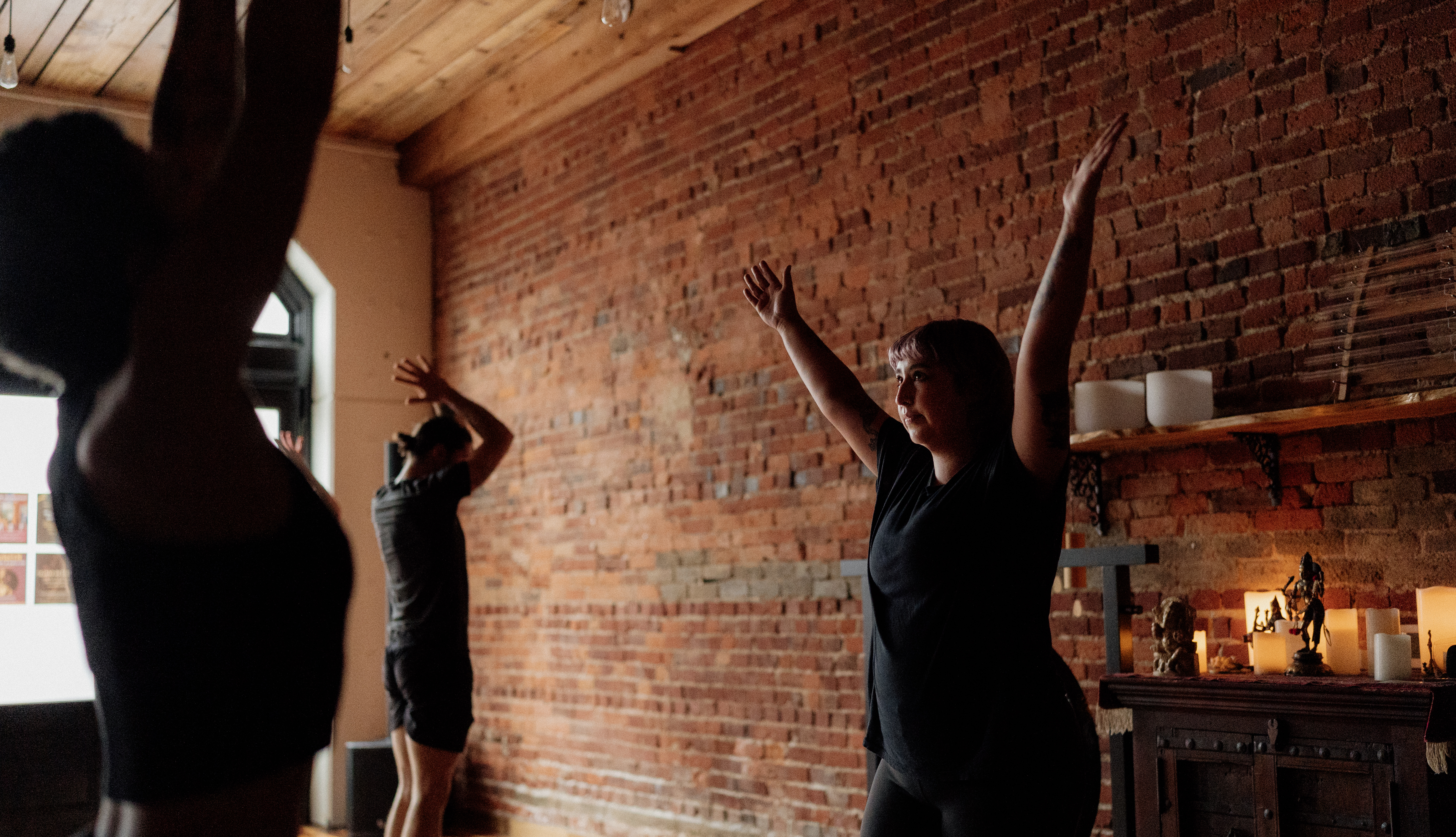 Woman practicing yoga in front of a brick wall