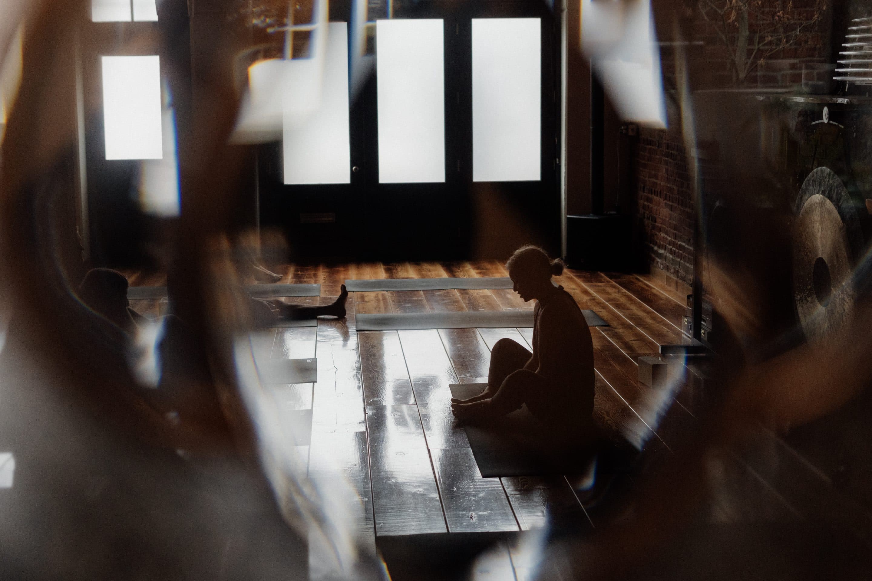 Woman sitting in a yoga studio with hands in her lap